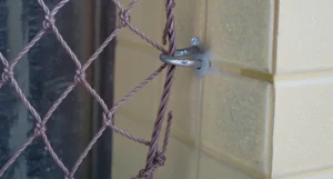 Detalhe de um gancho de aço inox, o modelo mais seguro para rede de proteção.
